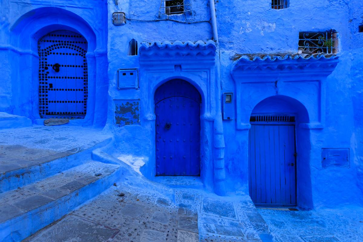 Calle de Chefchaouen con puertas pintadas de azul.